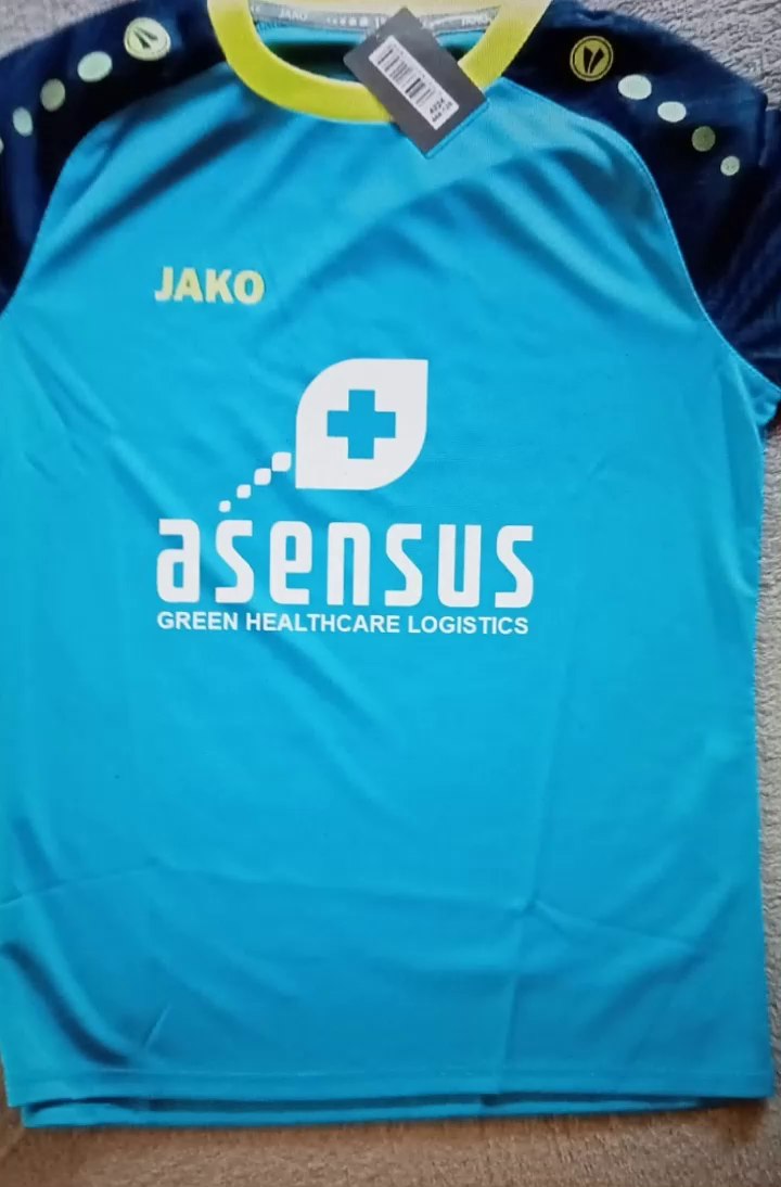 Blaues Jako-Fußballtrikot mit dem weißen Logo von asensus Green Healthcare Logistics auf der Brust.
